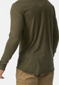 Olijfgroene lange mouw blouse met een afgeronde zoom, gemaakt van een zachte, gestructureerde stof; heeft gestikte details langs de schouders.