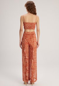 adL FLYWELL - Pantalones - Printed Orange