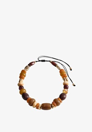 Náramek z korálků s jantarem, hnědými a krémovými kameny, obsahující směs tvarů a velikostí, na černé nastavitelném šňůře se zlatými akcenty.