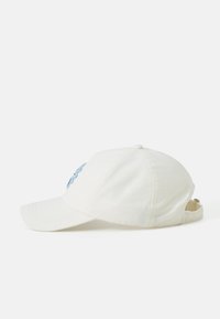 White cotton baseball cap with a curved brim, featuring blue embroidered design on the front and an adjustable strap at the back.