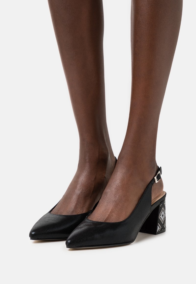 Escarpins à bride arrière noirs avec bout pointu, cuir texturé et talon bloc décoratif à motif. Bride ajustable avec accent métallique.
