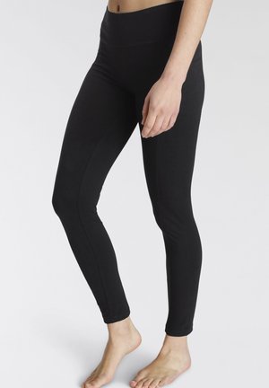 Schwarze Leggings aus dehnbarem Stoff, mit hohem Bund und einem eleganten, figurschmeichelnden Design, das bis zu den Knöcheln reicht.