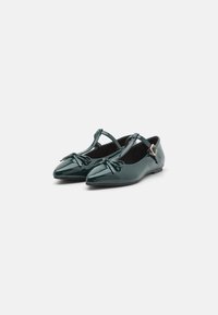 Green patent leather ballet flats with a pointed toe, T-strap design, bow accent on the front, and a small buckle detail on the strap.