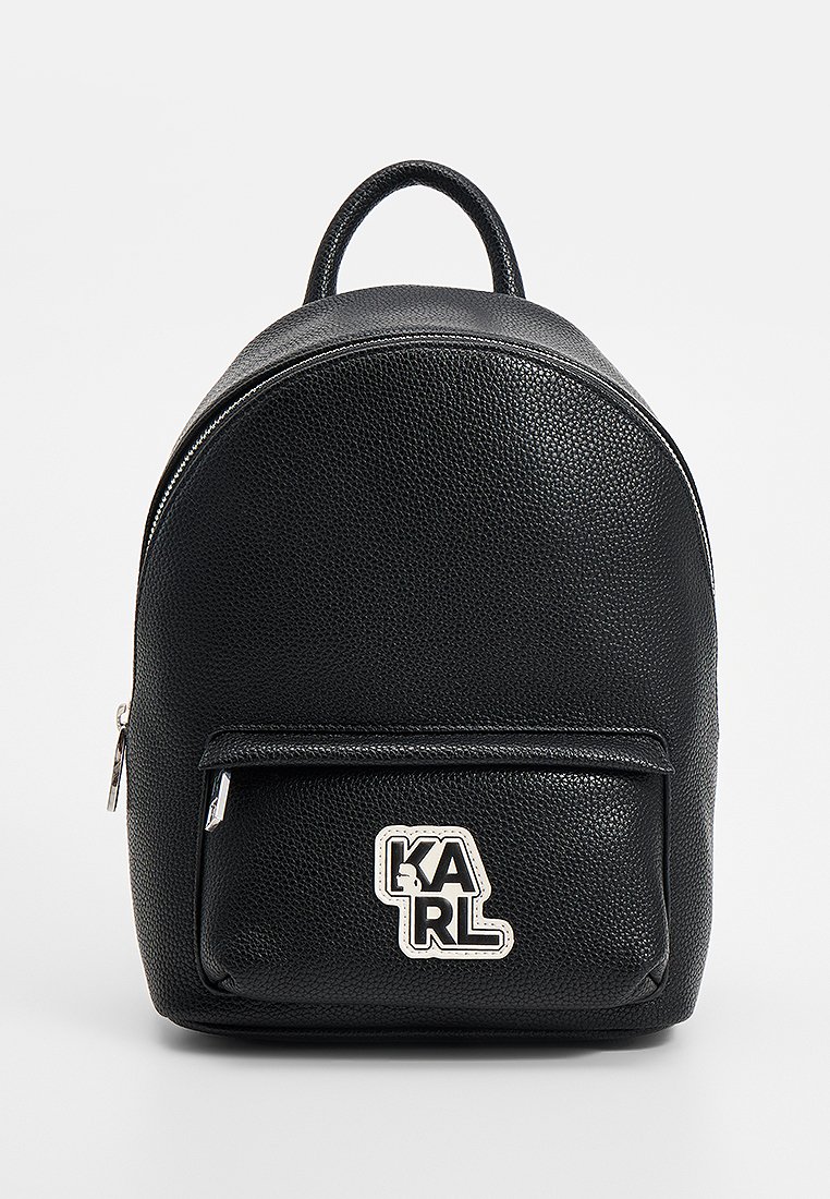 Czarny plecak ze strukturalnej skóry, z przednią kieszenią na zamek i srebrnym logo KARL na kieszeni, wyposażony w górny uchwyt i główny zamek błyskawiczny.