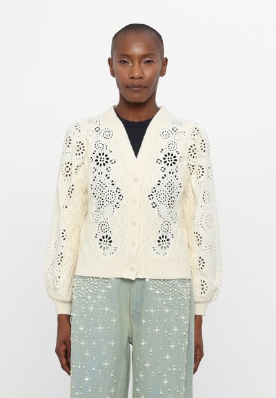 Cremfarbener Strickcardigan mit floralen Spitzenmustern, Knopfleiste und geripptem Saum. Verfügt über Puffärmel und feine Details überall.