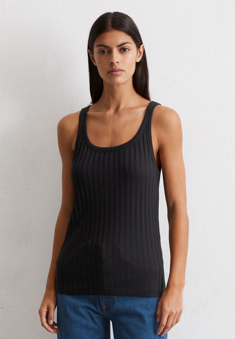Czarny prążkowany top na ramiączkach z okrągłym dekoltem i szerokimi ramiączkami, o dopasowanym kroju i miękkiej fakturze. W zestawieniu z niebieskimi dżinsami.