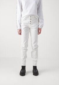 Bílé džíny s pěticípým zapínáním, slim fit a mírným protažením. V kombinaci s bílou mikinou a černými robustními botami. Hladká textura.