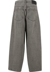 Jean larges gris en denim. Dotés d'une taille haute, de deux poches arrière et d'une patch en cuir noir au niveau de la taille. Tissu texturé.