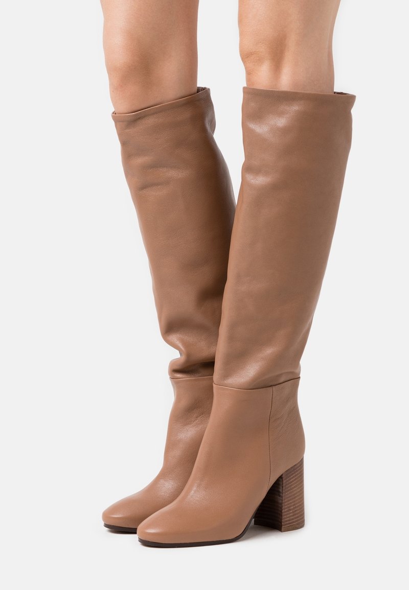 Knöchelhohe braune Lederstiefel mit runder Zehenform und Holzblockabsatz. Glatte Textur mit einer lässigen Optik über dem Knöchel.