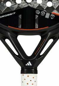 Black paddle racket with a textured carbon fiber surface, pronounced V-shaped frame, and a white grip with perforations and orange accents.