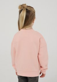 Felpa rosa con scollatura a girocollo e spalle scese, caratterizzata da una texture morbida e polsi a coste, vista da dietro.