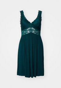 Hame dressi tumma tealsävyinen, jossa on pitsinen yläosa ja olkaimet, V-pääntie, pieni nauhakoriste ja ilmava hame, joka ulottuu reiden puoliväliin.