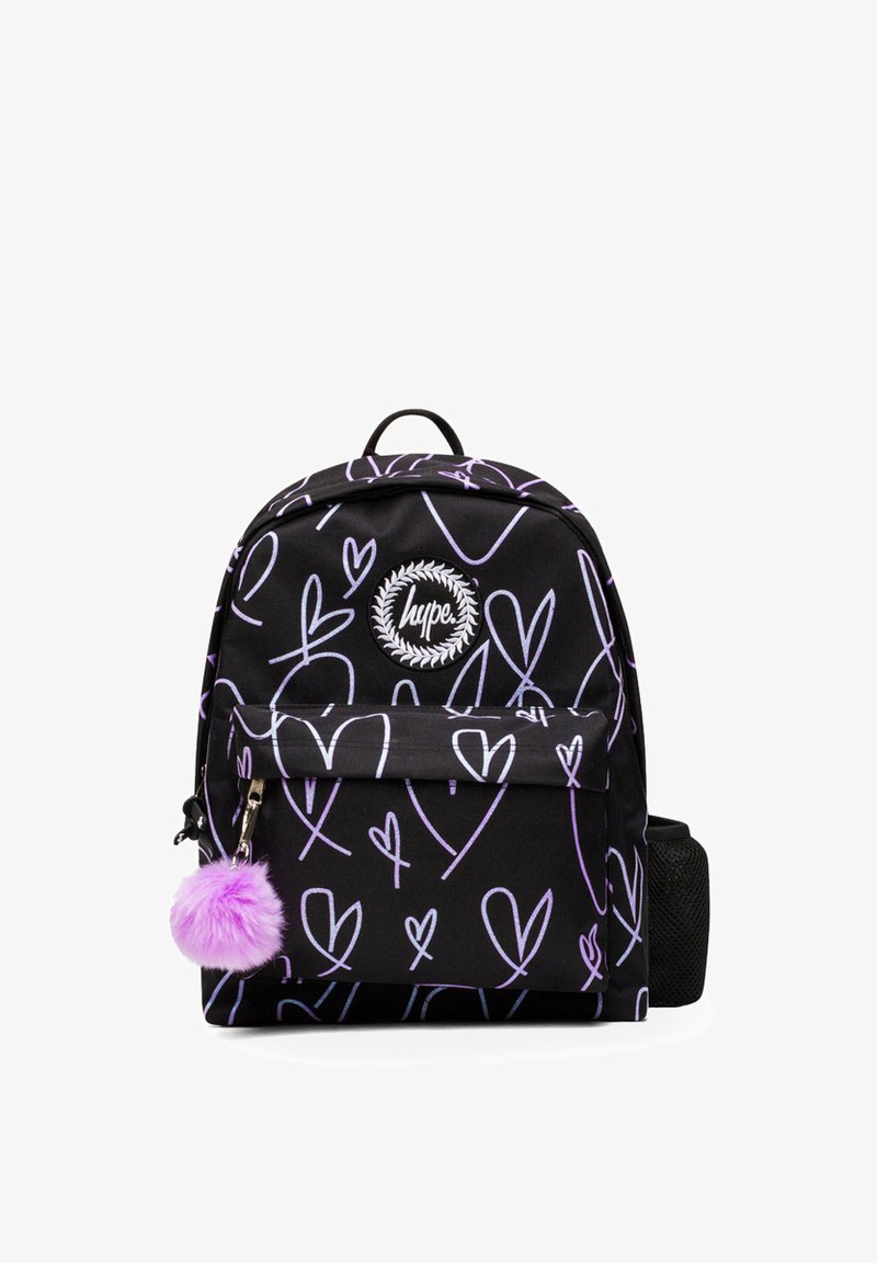 Musta reppu, jossa on valkoisia ja laventelinvärisiä sydänkuvioita, pyöreä logo-otsikko, etutasku ja purppuranvärinen pom-pom vetoketjun vetäjä.