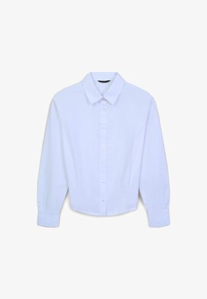 Chemise blanche à manches longues avec un col pointu, texture lisse et plis subtils sur les manches, dotée d'une fermeture à boutons sur le devant.