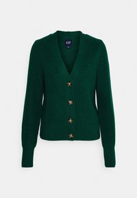 Grön stickad kofta med djup V-hals, ribbstickade muddar och nederkant, med fem stora bruna knappar framtill.