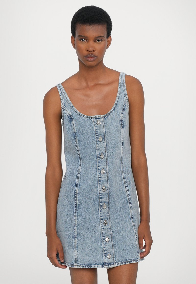 Denim-Minikleid in Hellblau mit Rundhalsausschnitt, Knopfverschluss vorne und figurbetonter Form. Es hat eine glatte Textur und dezente Nähte.