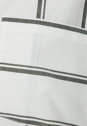 Gestreifter Stoff in Weiß und Dunkelgrau mit einer Tasche und kontrastierenden Nahtdetails. Weiche Textur, leichtes Material.