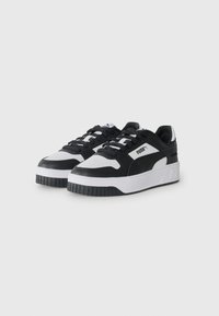 Black and white sneakers with a smooth synthetic upper, padded collar, thick white midsole, and textured black rubber outsole.