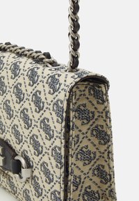 Bolso de lona en crema con un patrón geométrico azul, que presenta herrajes plateados, una correa de cadena y un cierre magnético.