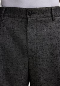 Grijze broek met een herringbone-patroon en een gladde textuur, met een zwarte knoopsluiting op de taille en standaardzakken.