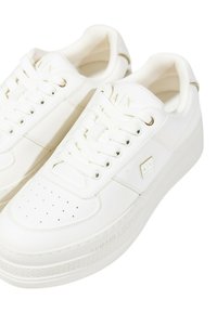 Sneaker bianchi con tomaia in pelle liscia, punta perforata, lacci piatti e suola rialzata caratterizzata da dettagli del marchio in rilievo e accenti metallici.