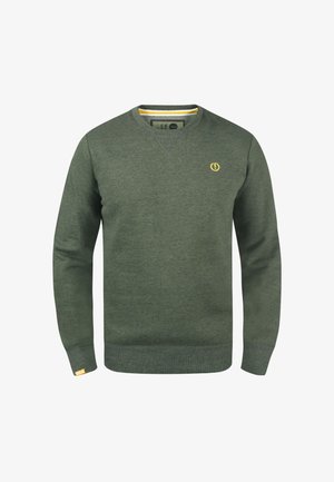 Zelena majica s kapuco z V-izrezom, narejena iz mehke tkanine. Ima majhen rumen logotip in rumeno obrobo na notranji strani izreza.