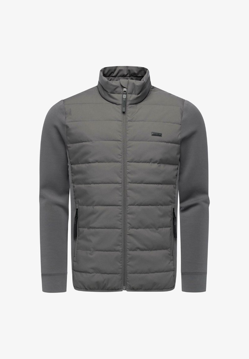 Harmaa takki korkealla kauluksella, jossa on tikattu etupaneeli, sileät hihat, vetoketjullinen suljin ja sivutaskut. Kankaan pinta on teksturoitu ja siinä on kontrastielementtejä.