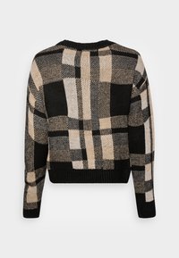 Skrócony sweter dzianinowy z czarno-beżowo-kremowym wzorem w kratkę. Posiada ryglowy dekolt i mankiety oraz miękką teksturę.