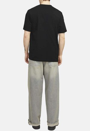 Camiseta de algodón negra combinada con jeans de pierna ancha en gris claro. La camiseta tiene un cuello redondo clásico y mangas cortas. Detalles mínimos.