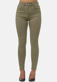 Jeans skinny de talle alto en verde oliva, con cinco bolsillos, confeccionados en una mezcla de algodón elástico, que presentan una textura suave y un corte ajustado.