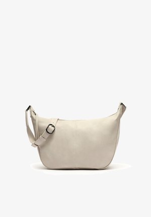 Beige nahkaolkalaukku, jossa on kaareva muoto, säädettävä hihna ja yksityiskohtainen ommel. Tasainen pinta ja minimalistinen muotoilu.