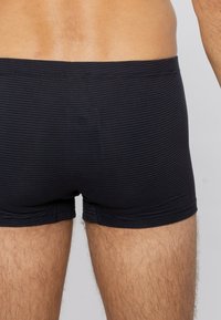 Mörkblå randiga boxershorts i mjukt tyg, med en tajt passform, platta sömmar och ett elastiskt midjeband utan etiketter.