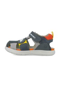 Sandal gris y marino con acentos en naranja, amarillo y gris. Correa ajustable de Velcro, diseño de punta abierta y suela de goma texturizada.