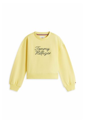 Żółta bluza z długim rękawem i okrągłym dekoltem, z wyhaftowanym po czarnym kursywie napisem „Tommy Hilfiger” na przodzie oraz ściągaczami na mankietach i dole.