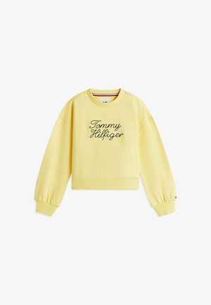 Żółta bluza z długim rękawem i okrągłym dekoltem, z wyhaftowanym po czarnym kursywie napisem „Tommy Hilfiger” na przodzie oraz ściągaczami na mankietach i dole.