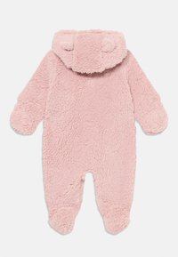 Mono de felpa rosa con un exterior texturizado y esponjoso, capucha con orejas de animal y puños en las mangas y piernas para mayor calidez.