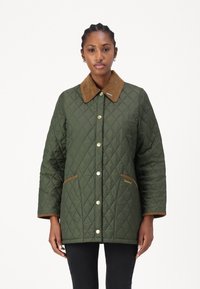 Πρασινός επενδυμένος μπουφάν με καφέ κορδέλα, κουμπιά με σ snap, πλαϊνές τσέπες και κεντητό λογότυπο στην αριστερή τσέπη.