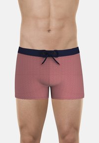 Shorts de bain pour hommes en rouge avec un motif ondulé blanc, dotés d'une taille élastique marine et d'un cordon de serrage.