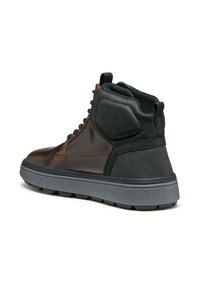 Zapato alto de cuero marrón con acentos negros, lados texturizados y una suela de goma gris. Cordones que recorren la parte delantera; collar acolchado para mayor comodidad.