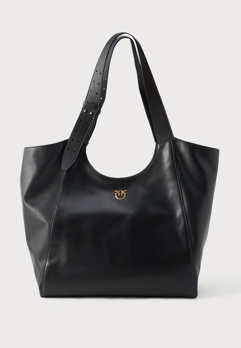 Bolsa de tote em couro preto com alça de ombro larga e ajustável, e pequeno logótipo dourado centrado abaixo da borda superior curva.