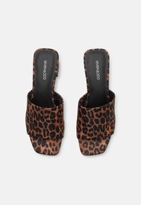 Damesandaler med leopardmønster og bred, myk tekstiloverdel, firkantet tå og flat såle. Sort innersåle med merkevarelogo.
