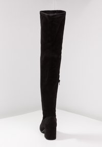 Czarne kozaki za kolano wykonane z miękkiego zamszu, z masywnym obcasem i bocznym zamkiem błyskawicznym dla łatwego zakładania. Gładka faktura i elegancki design.