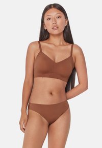 Brązowy stanik z cienkimi, regulowanymi ramiączkami i pasującymi majtkami bikini, wykonany z gładkiego, elastycznego materiału o bezszwowym designie.