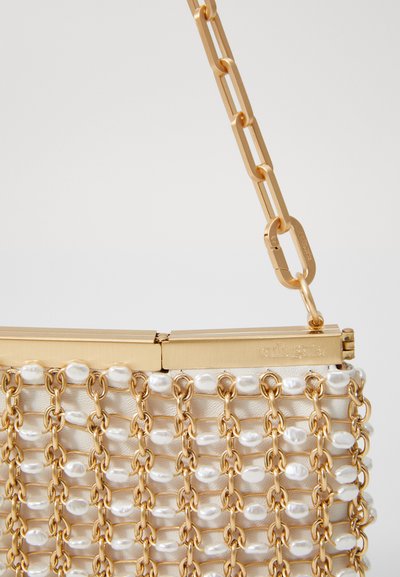 Goldene Kettenhandtasche mit einer strukturierten Form und einem dekorativen Muster aus Perlen. Glatte cremefarbene Oberfläche mit einem metallischen Verschluss.