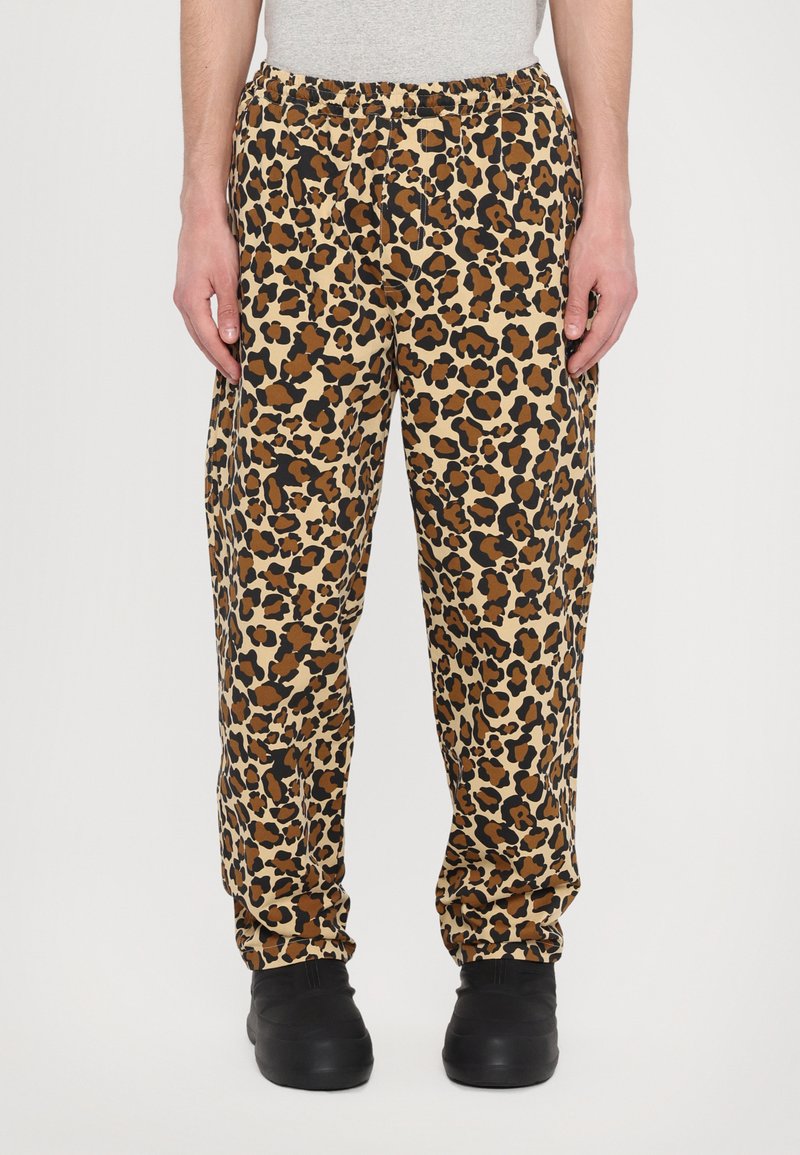 Leopard print pants in tan, brown, and black hues. Features an elastic waistband and cuffed ankles, made from a lightweight fabric.