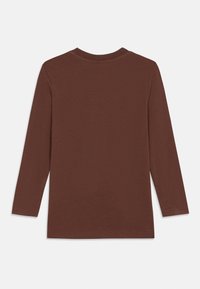 Pitkähihaisen ruskean paidan, joka on valmistettu pehmeästä puuvillasta. Siinä on pyöreä pääntie ja suora helma ilman näkyvää brändäystä tai kuvioita.