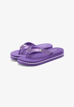 Lila Platform-Zehentrenner mit glitzernden Riemen, einem silbernen Knopfdetail und weißen Sohlenstreifen, schräg auf weißem Hintergrund gezeigt.