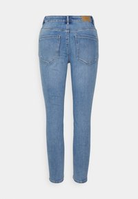 Jeans skinny em denim azul claro, com cintura de altura média, design de cinco bolsos e um rótulo em couro castanho na parte de trás da cintura.