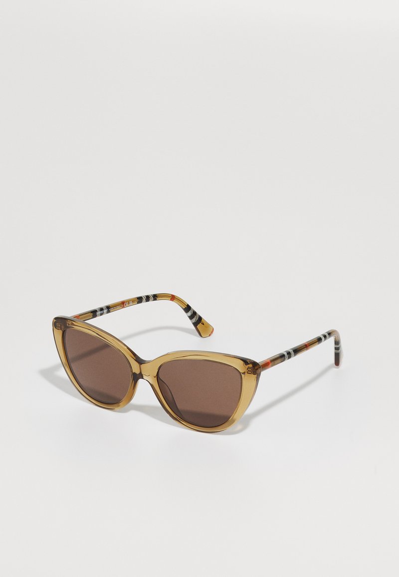 Cat-eye sunglasses with a transparent amber frame and brown lenses. The arms feature a striped pattern in black, white, and orange accents.