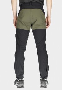 Herroutdoorbyxor med svart nederdel och olivgrön överdel. Har en ventilerande design, justerbar midja och fickor med dragkedja.